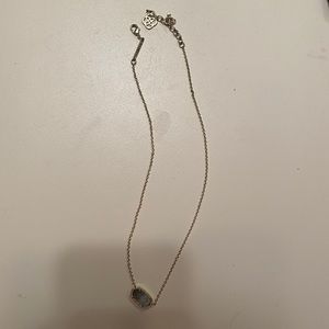 Gold kendra scott necklace with grey “jewel”